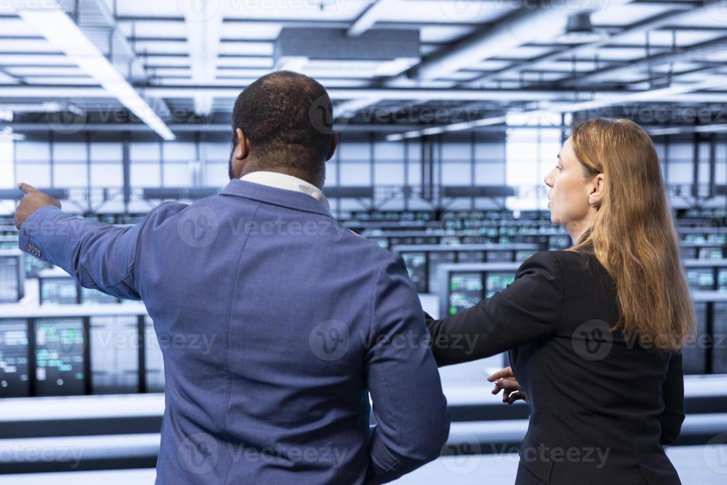 Team of engineers in server hub checking hardware after installing storage units. Teamworking colleagues in data center doing maintenance after replacing mainframes components photo