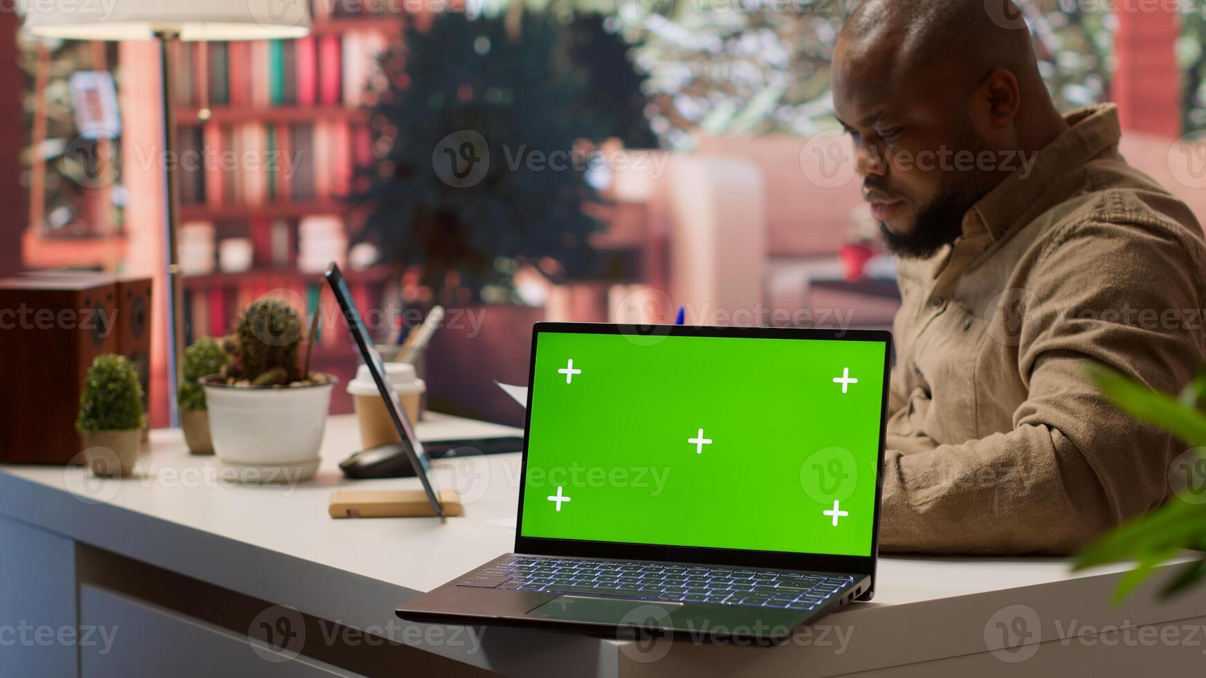 Startup administrator calculates economic budget balance at his home office, using isolated chroma key green screen. Entrepreneur reviews monthly sales reports, investment funds. Camera A. photo