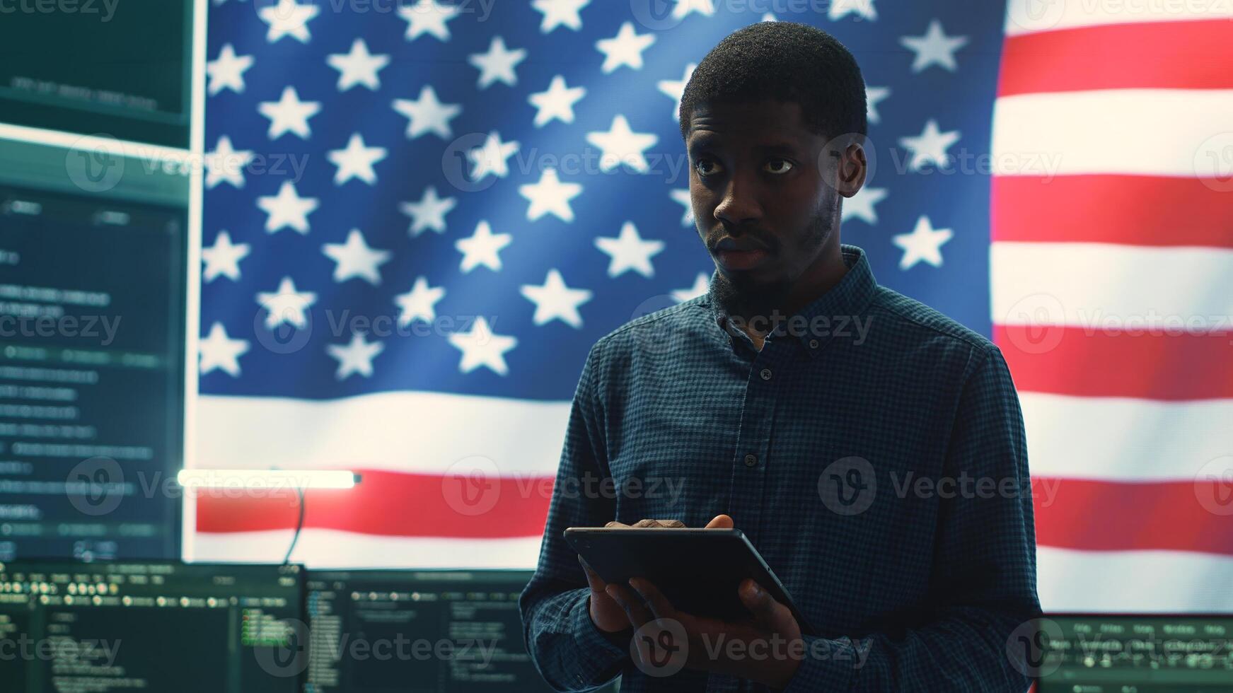 Cybersecurity expert working in a governmental hacking room with the American flag shown on big screen. Safeguarding data protection and doing cyber threat analysis in a high tech office. Camera A. photo