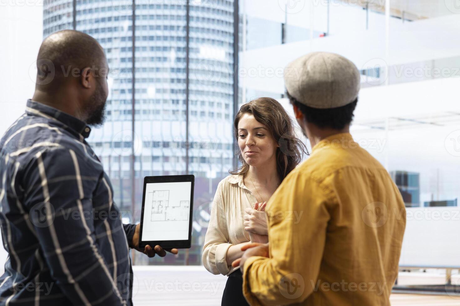 Business management team planning an office relocation and seeing new high class space tour with the broker, analyzing blueprints. Reaching a legal agreement with leasing contract. photo