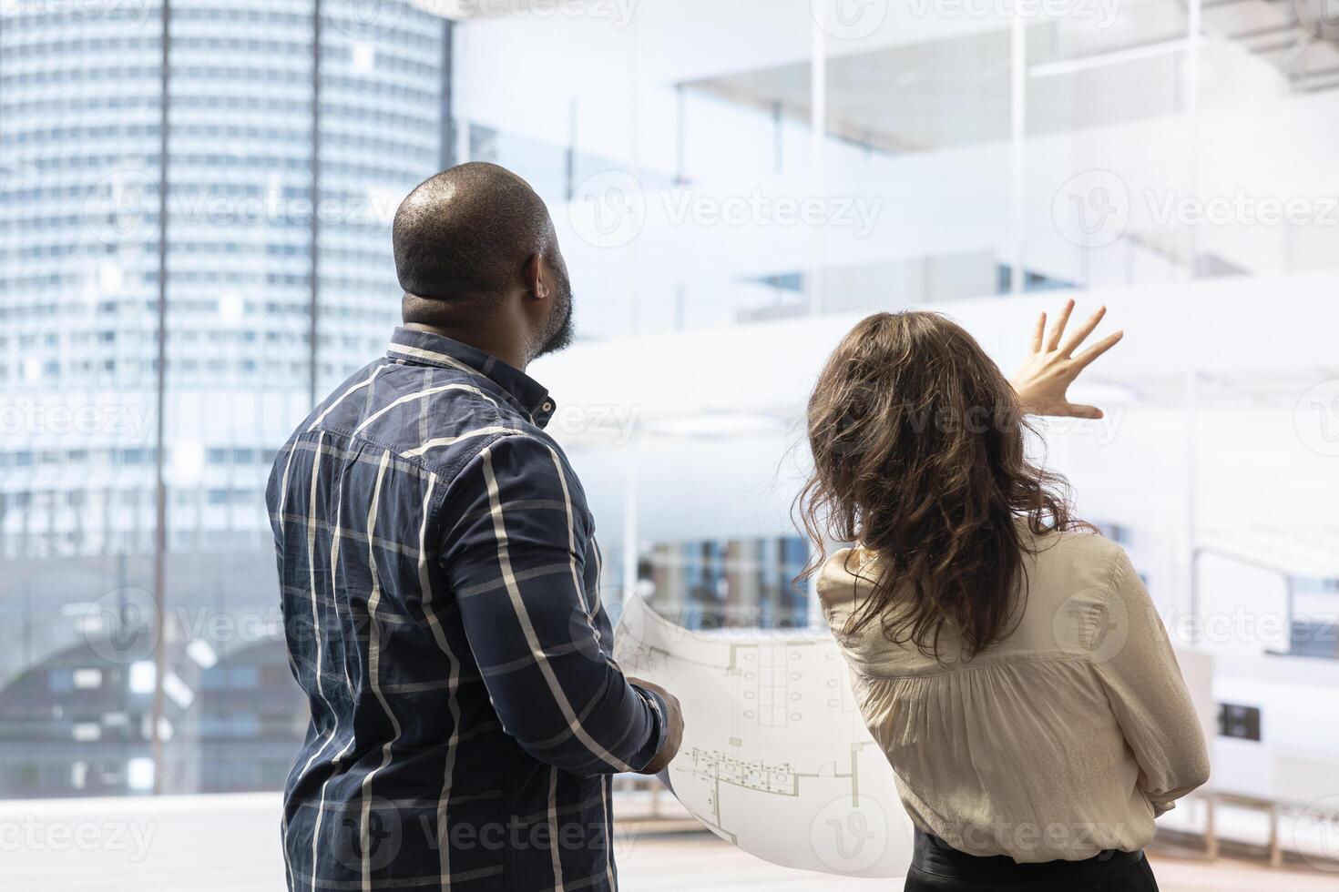 Broker and client sharing a development vision for the new office space in a high class urban building, realtor working with entrepreneur to negotiate a property leasing contract. photo