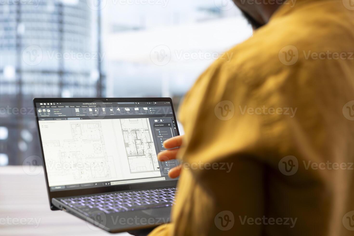 Property broker presenting real estate investment opportunity to a client, reviewing blueprints layouts on a laptop for a leasing contract. Agent discussing the architectural design for relocation. photo
