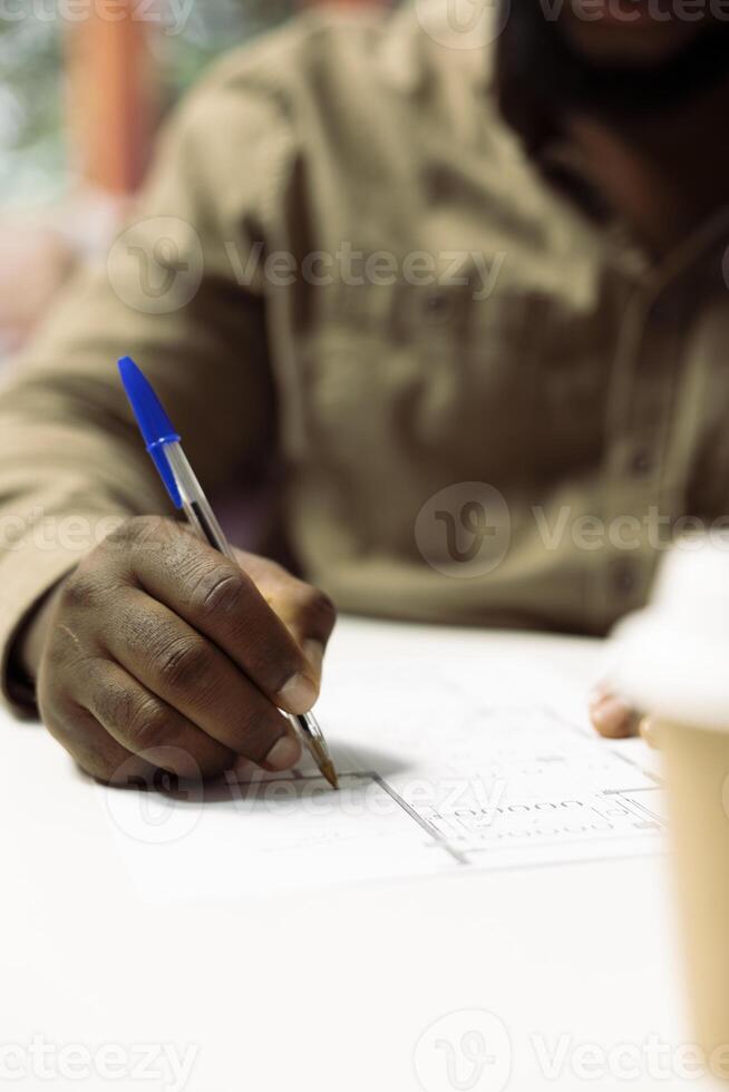 Young businessman evaluating architectural sketches and planning office spaces, focusing on blueprint review and strategic layout design. Using digital tools for creative workspace. Close up. photo
