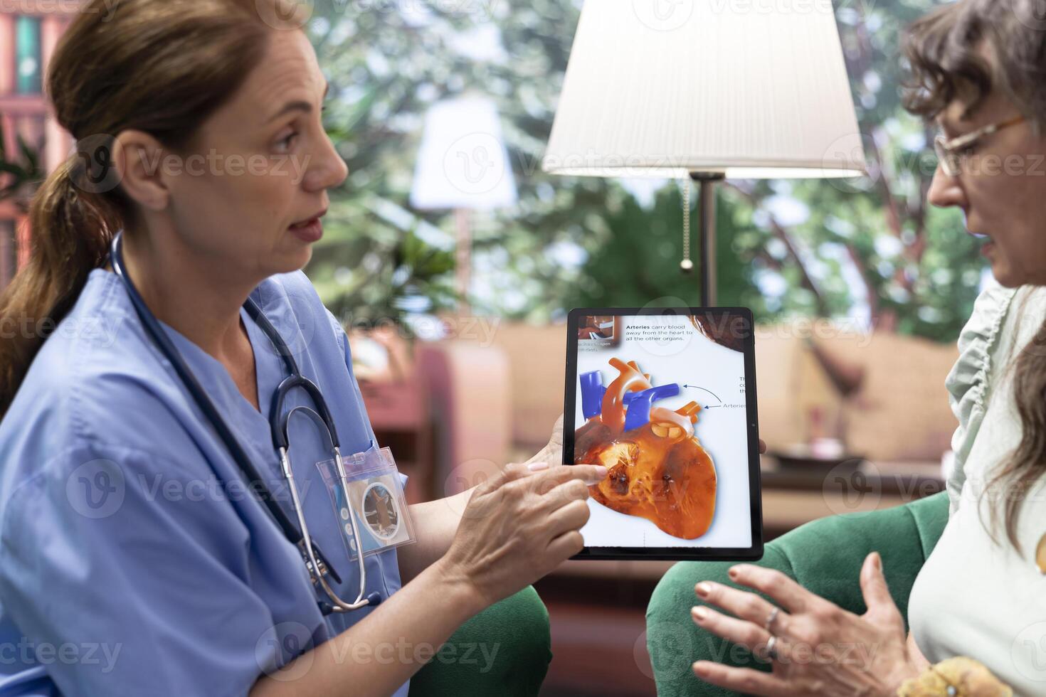 Skilled nurse explaining a heart condition or disease to elderly patients, cardiovascular system illustration during checkup visit at home. Healthcare and senior support for healthy recovery. photo