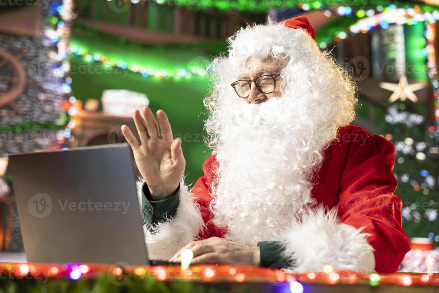 Saint Nicholas talking to parents and kids before Christmas eve, using web call to find out about gift wishes. Modern Santa using technology to make children happy, x mas cheer. photo