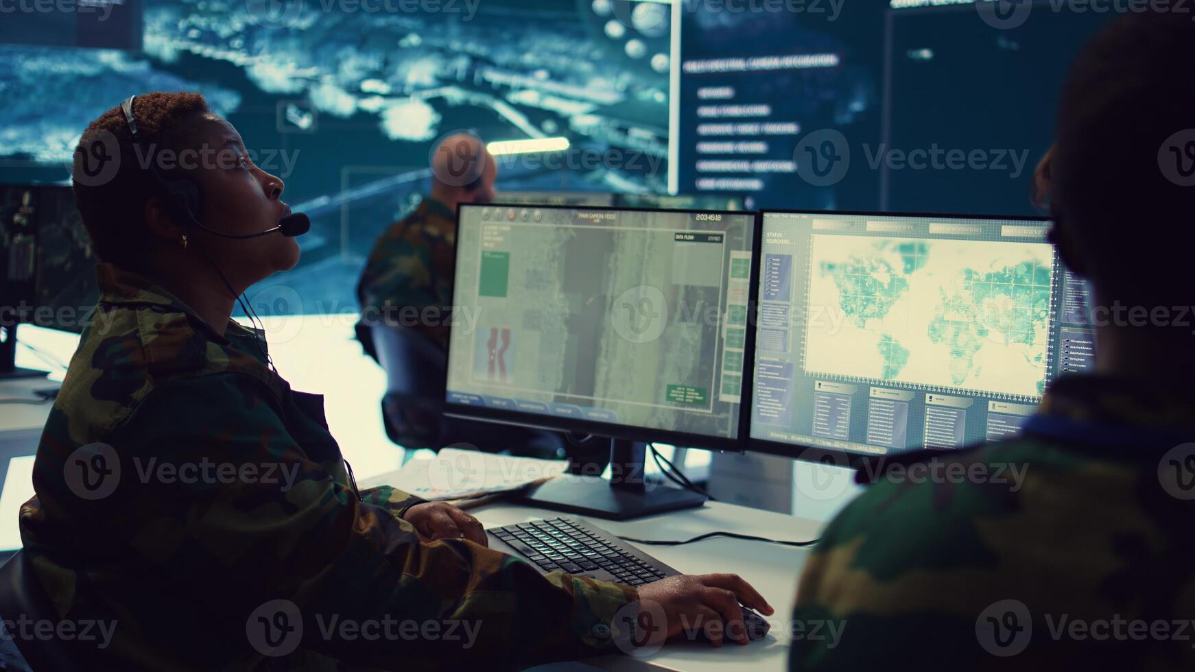 Woman army officer operates on gps surveillance footage to gather crucial information about enemy plans. Operator examines a satellite world map to provide support to field troops. Camera B. photo