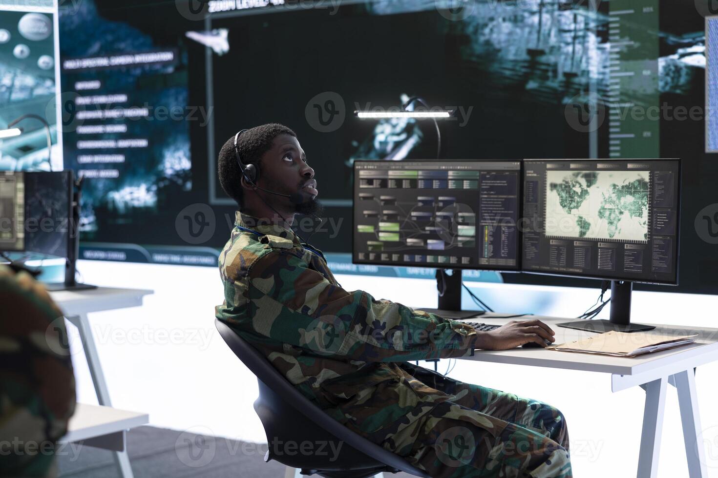 Army officer working with modern computer systems and satellite data for surveillance operations, gather intelligence to protect national interests. Strategic planning in a high tech base. photo