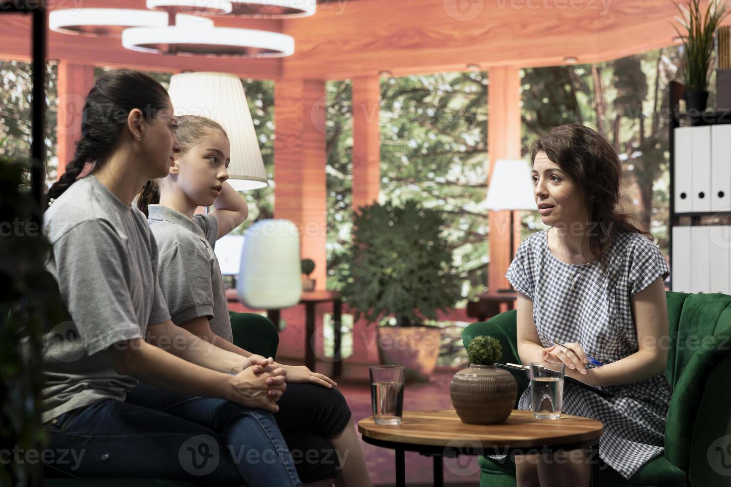 In a confidential therapy session teenage girl and her mother discuss personal troubles and emotional struggles. The therapist provides guidance for navigating adolescence and behavioral therapy. photo