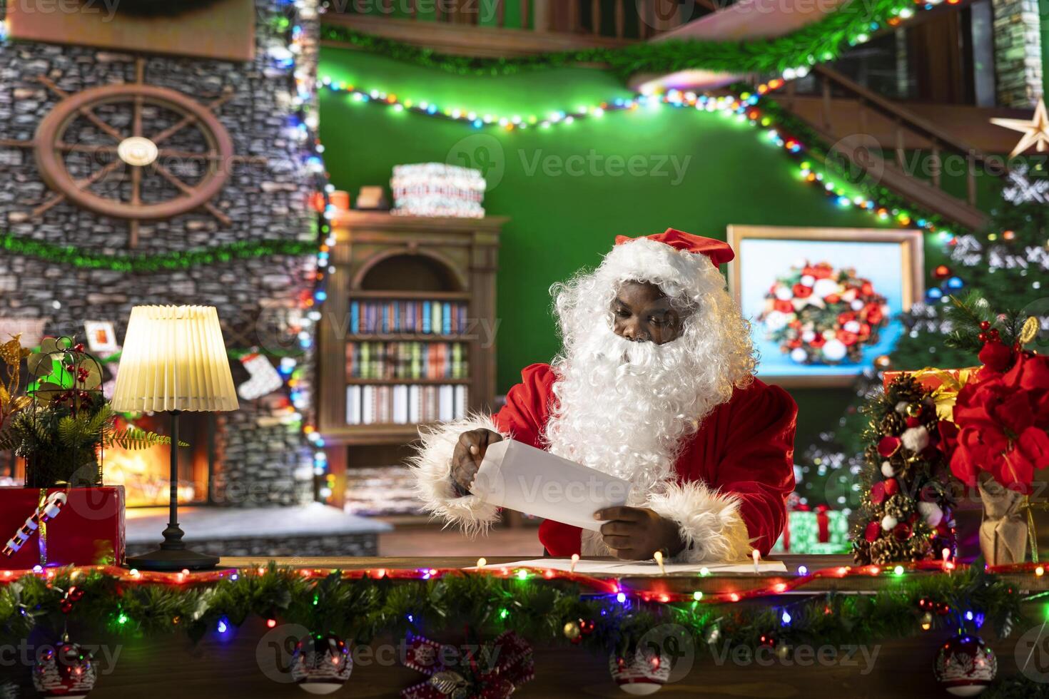 Father Christmas reading letters and lists in his festive workshop, white bearded man opening mailbox. Surrounded by holiday lights and decorations, Santa prepares gifts for joyful traditions. photo