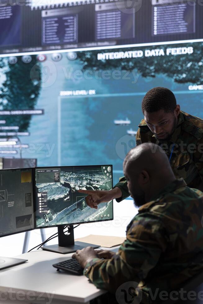 In a high tech military office, soldiers team analyze real time data collected by cctv surveillance system. Staff interpret intelligence and coordinate operations to ensure national defense mission. photo