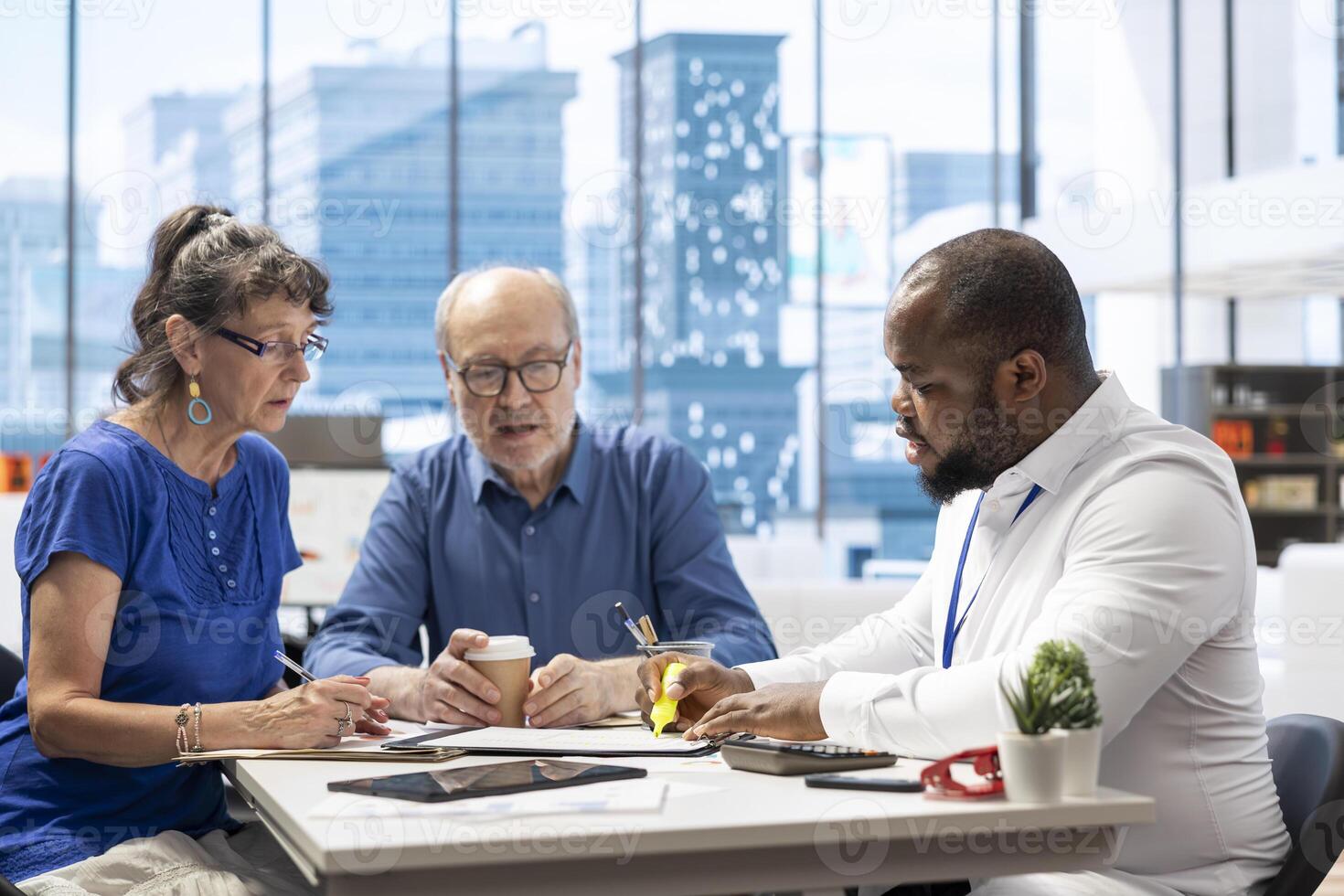 Elderly couple discussing about retirement plans with a financial planner, covering savings strategy and pension options. Middle aged people looking to invest to secure their budget. photo