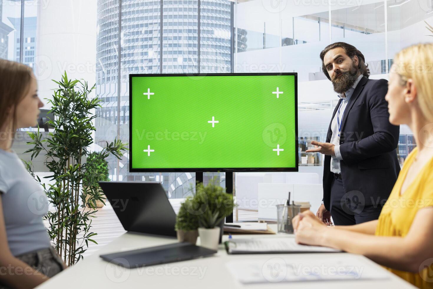 Financial advisor in office provides economic services to customers, showing them data on green screen. Consultant talks with clients about their banking accounts, doing presentation on mockup display photo
