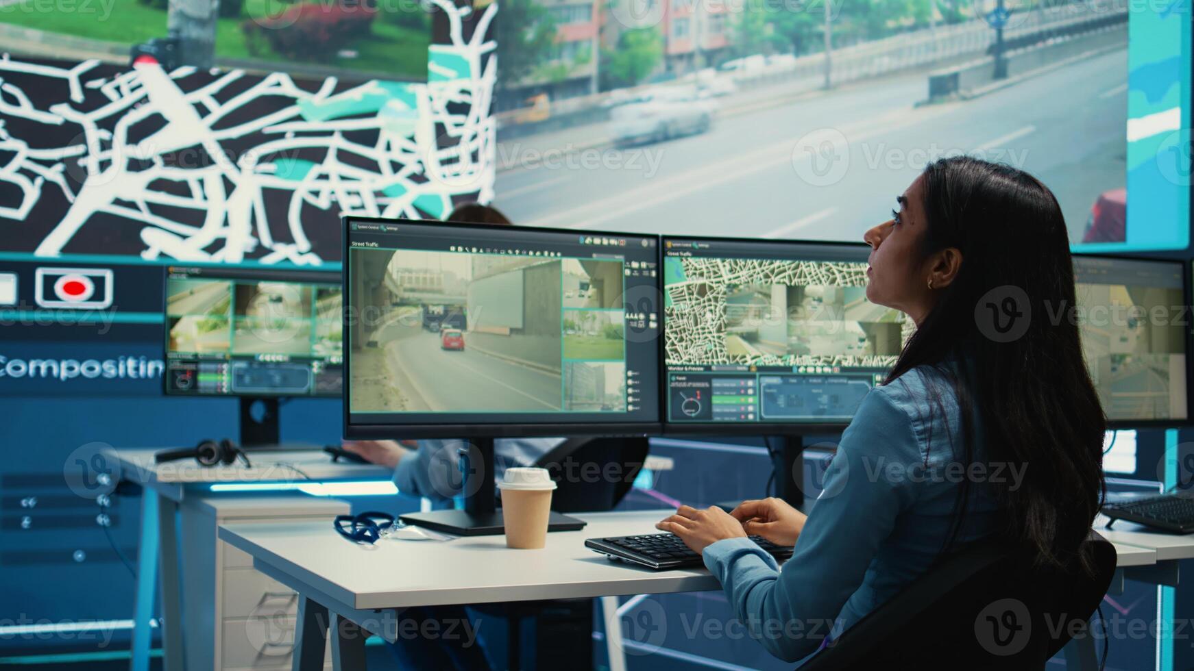 Indian shipping agency employee gathering data on traffic via surveillance footage, helping delivery trucks with cargo for shipment. Operator uses gps coordinates for tracking orders. Camera B. photo