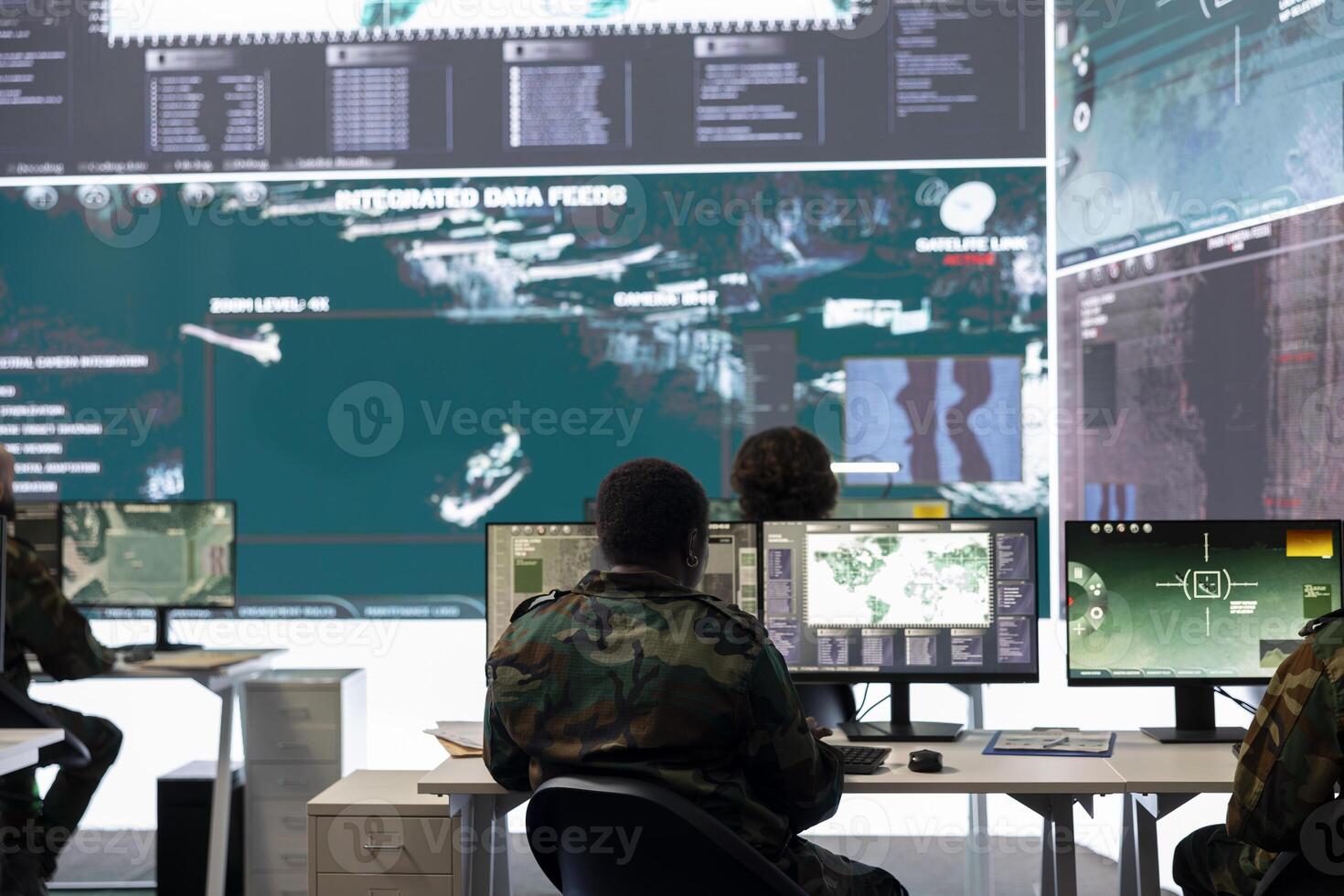 Army staff examining surveillance footage on big screen in operation room, gathering intelligence for a new defense mission. Diverse group of troopers working on reconnaissance activity. photo