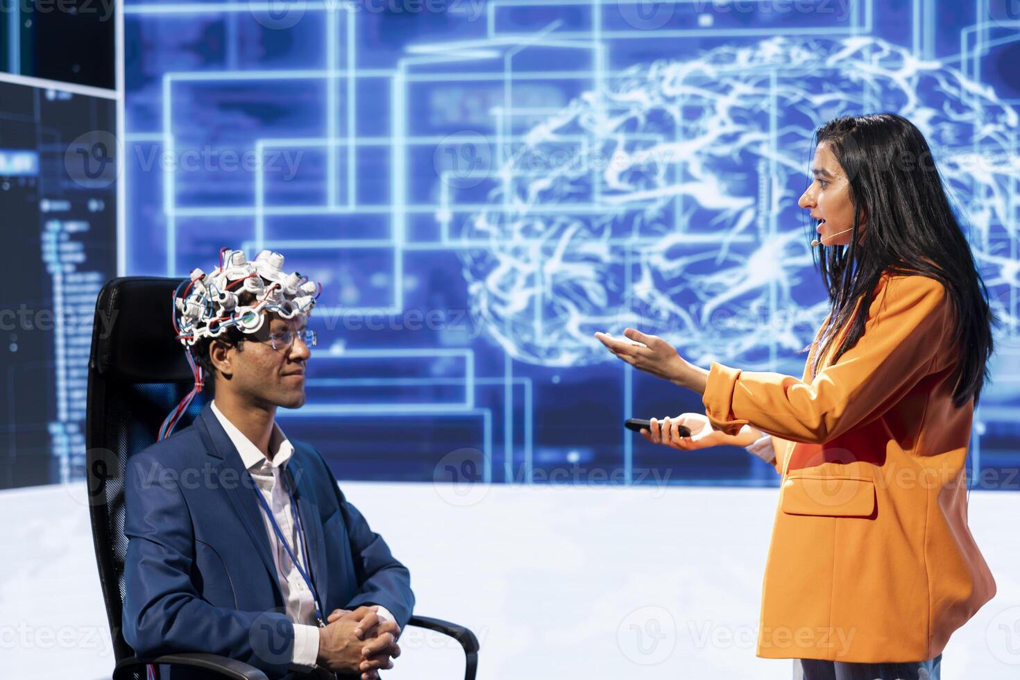 Presenter talking at AI neuroscience forum bringing together IT professionals, showing EEH headset demonstration of latest developments in artificial intelligence mind transfer photo