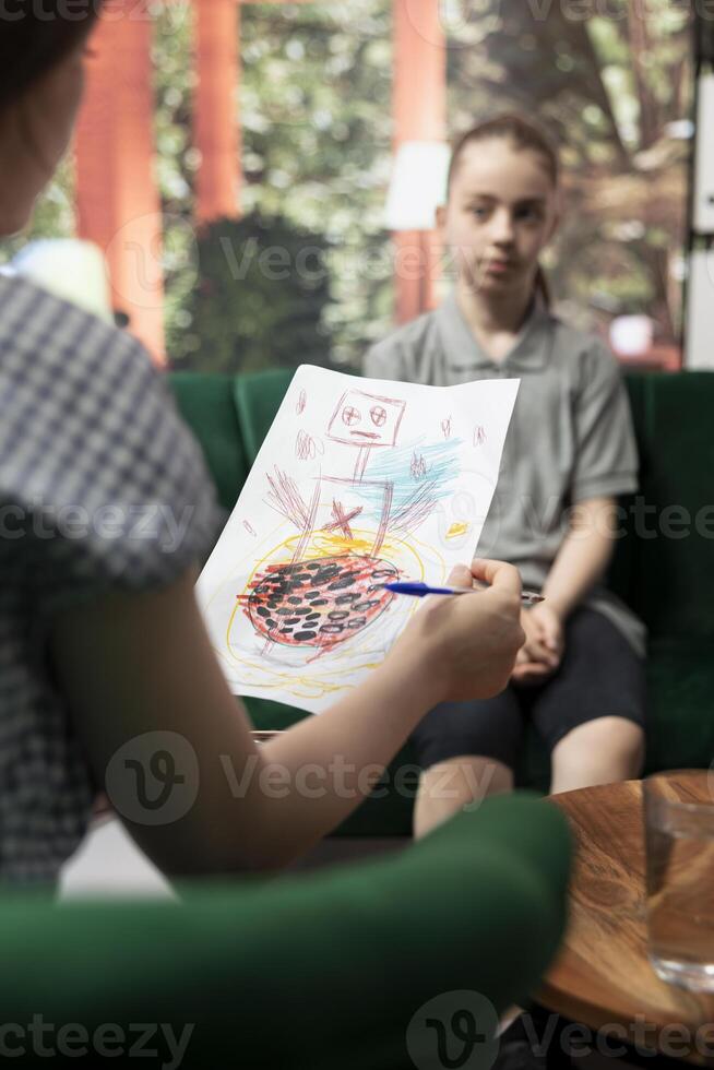 Psychologist reviewing scary sinister sketches by a troubled adolescent, displaying dangerous, unsettling emotions. The drawings suggest depression, aggression and social disorders. Close up. photo