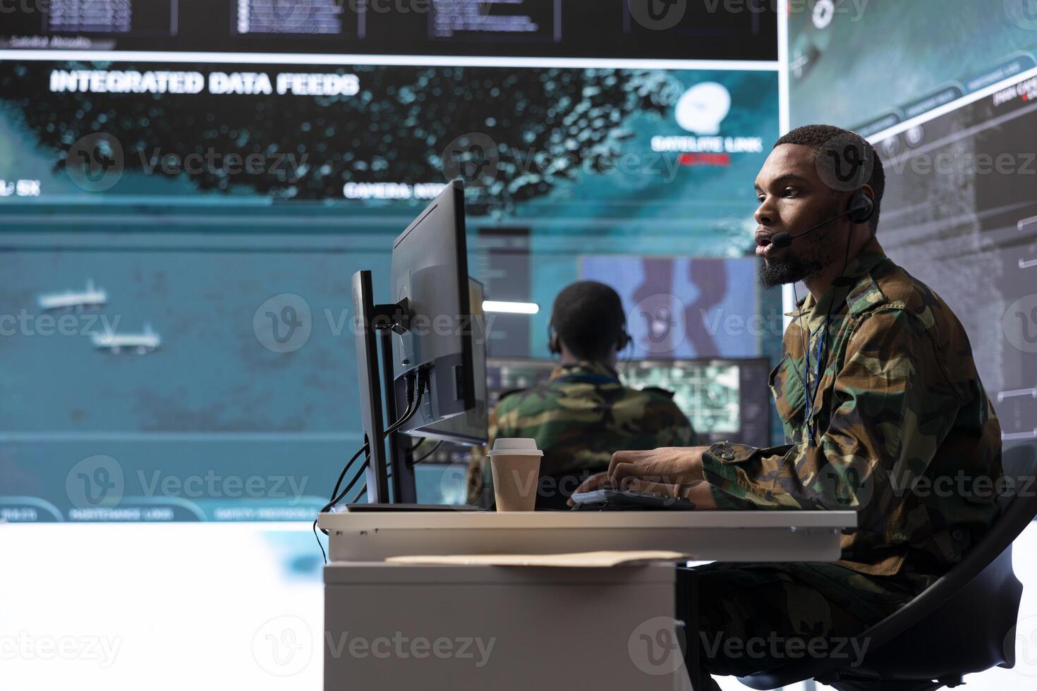 Military intelligence specialist using modern satellite systems and real time data to ensure national defense operations in a high tech control center base. Army professional working at computer. photo