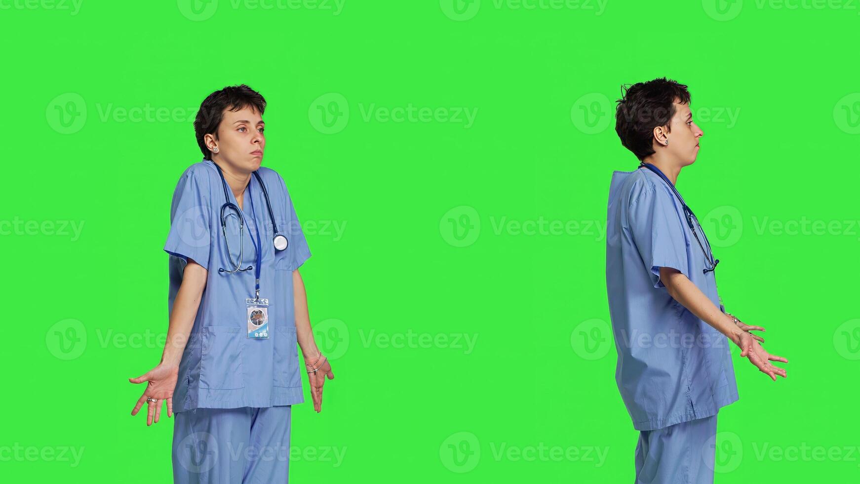 Medical assistant shrugging and doing i dont know sign in studio, acting clueless and uncertain against greenscreen backdrop. Nurse in scrubs gesticulating doubtful reaction, unsure girl. Camera B. photo