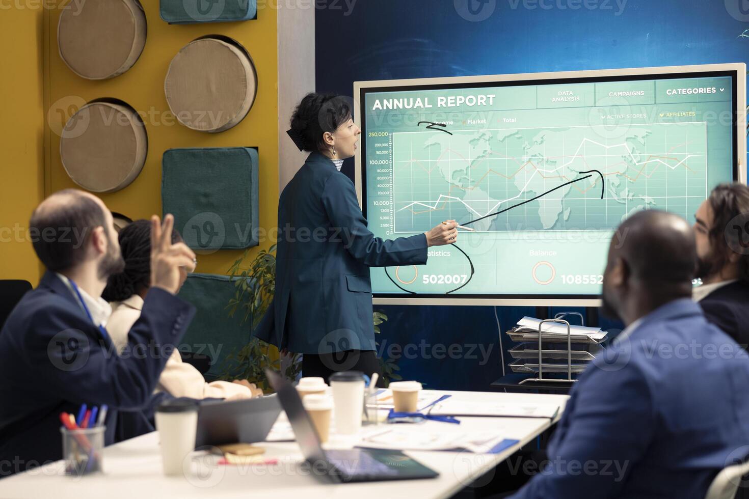 Management team studying annual infographics on interactive board, looking into market supply and demands to facilitate global development. Business associates review briefs in boardroom. photo