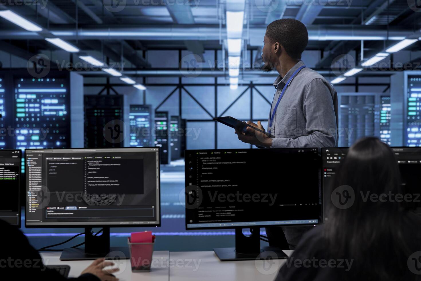 African american engineer doing yearly checkup to prolong data center electronics life span and avoid downtime. IT worker in server room monitoring server infrastructure components using tablet photo