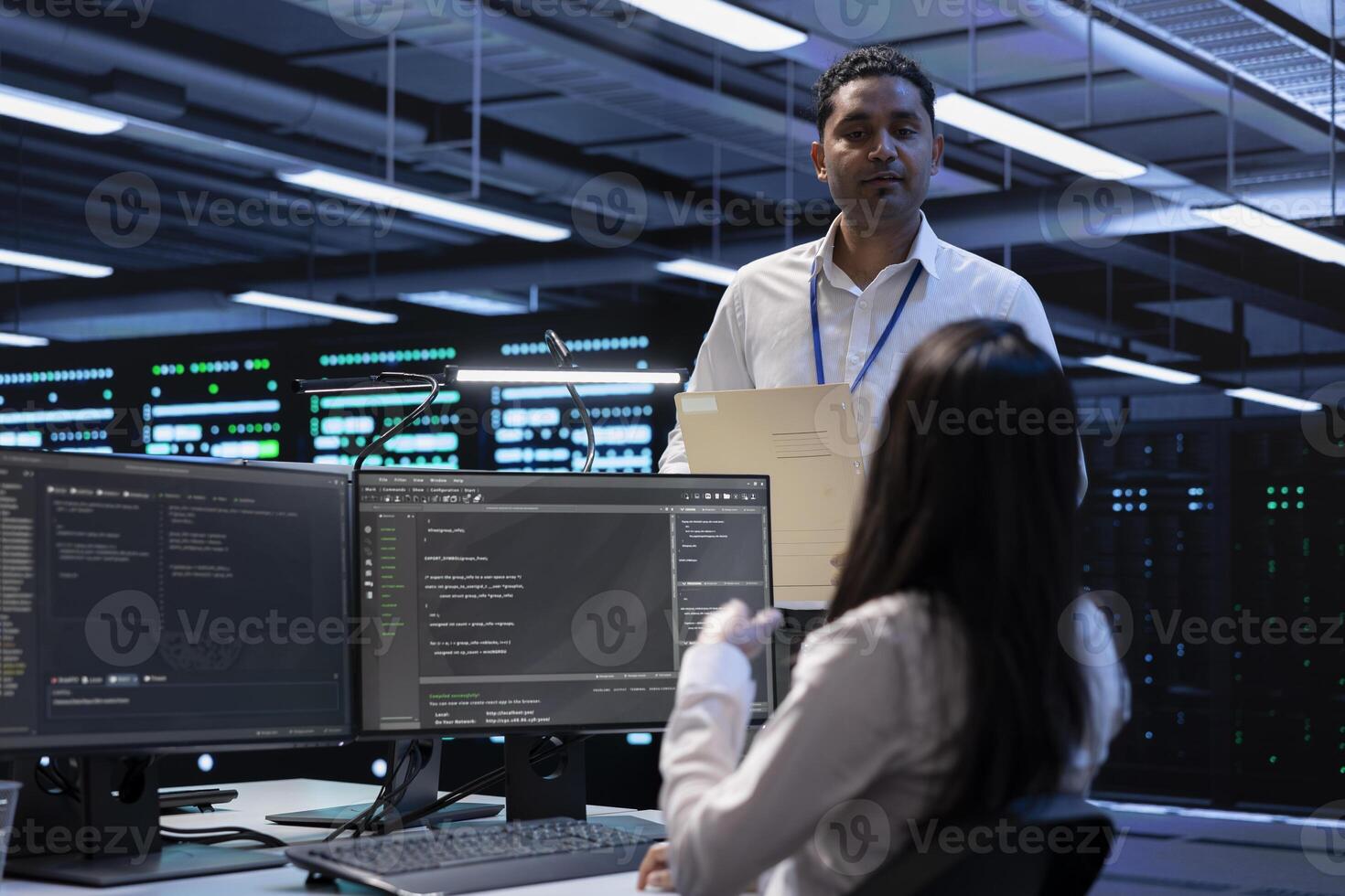 Team of engineers in data center looking for firewall misconfigurations affecting servers. Multiracial workers in server room check systems bottlenecks leading to sluggish data transfer rates photo