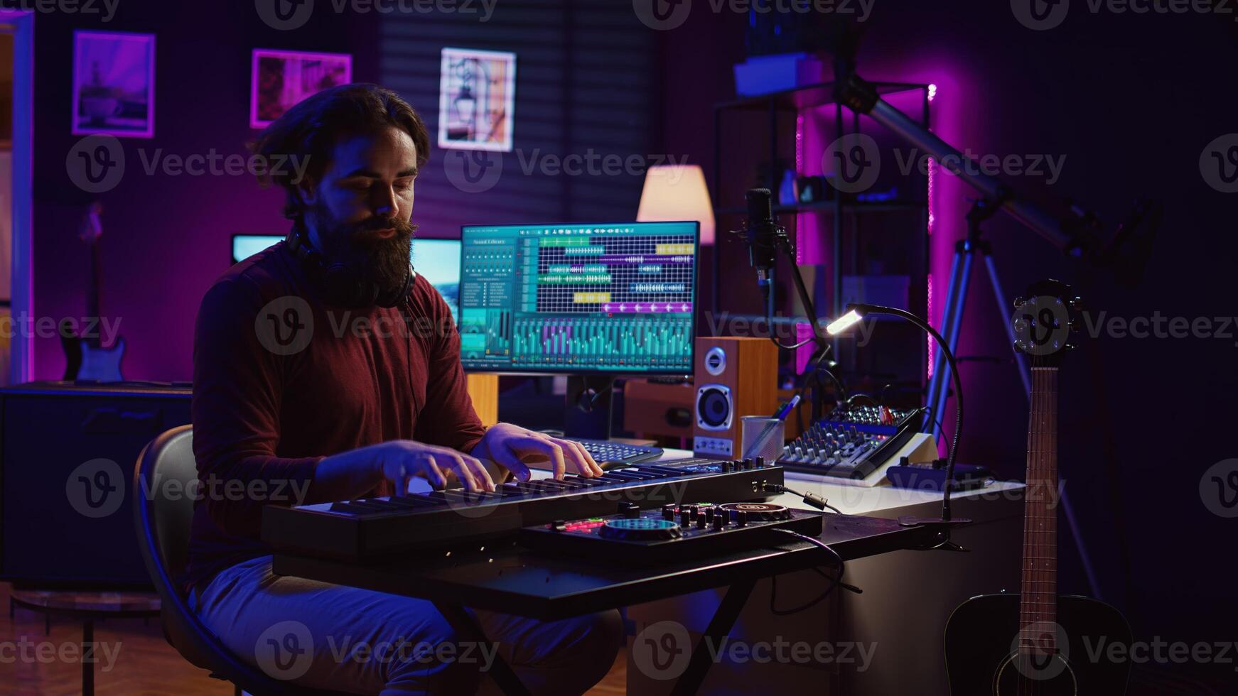 Sound engineer playing electronic piano keyboard and recording sounds, using mixing console and daw software to create new tunes. Music industry specialist uses stereo tools at home studio. Camera B. photo