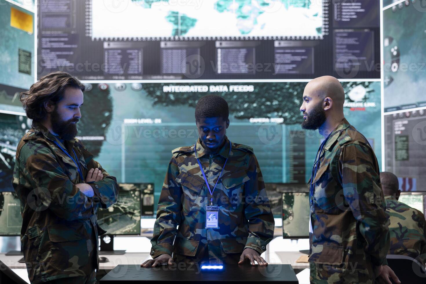 Team of diverse soldiers conducting intelligence gathering activity, studying footage on a hologram projection to help infantry units in the field. Trained troopers collect real time data. photo