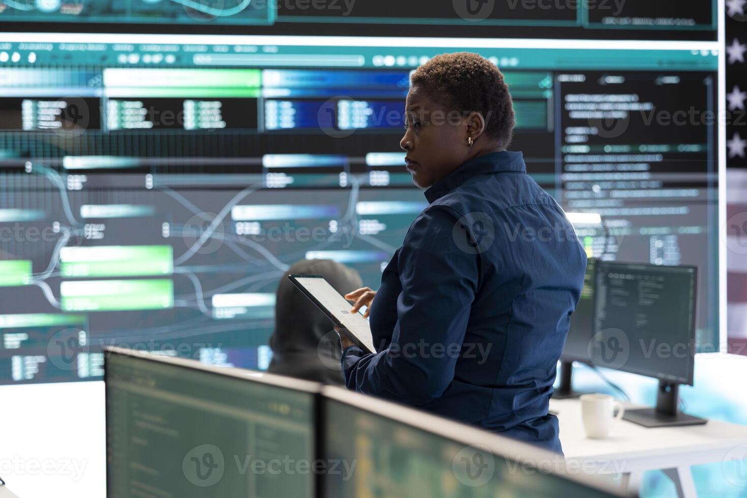 Cybersecurity specialists in a high tech office with the American flag, focusing on cyber intelligence and secure network operations. Works on information security and malware detection. photo