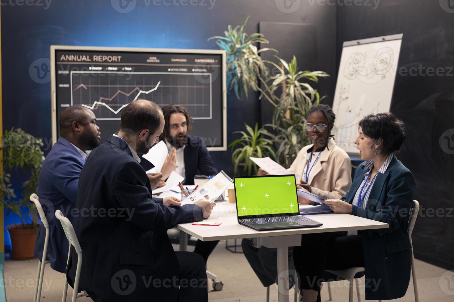 Promotions specialist and staff members meeting in a boardroom, using laptop with isolated mockup screen. Enterprise employees reviewing sales strategy in a fruitful conference, increase profit. photo