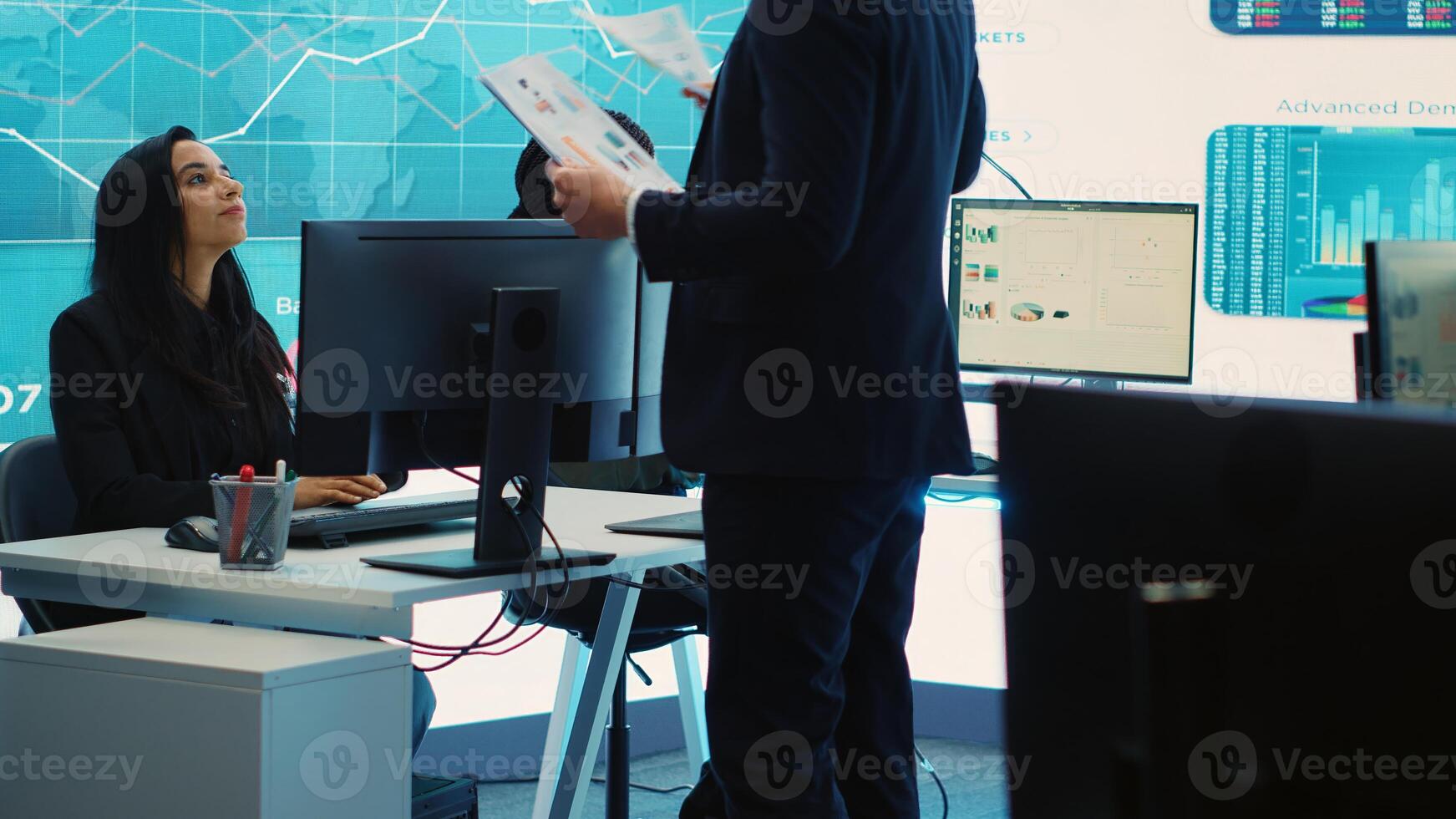 General director CEO sharing insight about a new development strategy with his employees, showing important data reports to analyze organizational activity status in a control room. Camera A. photo