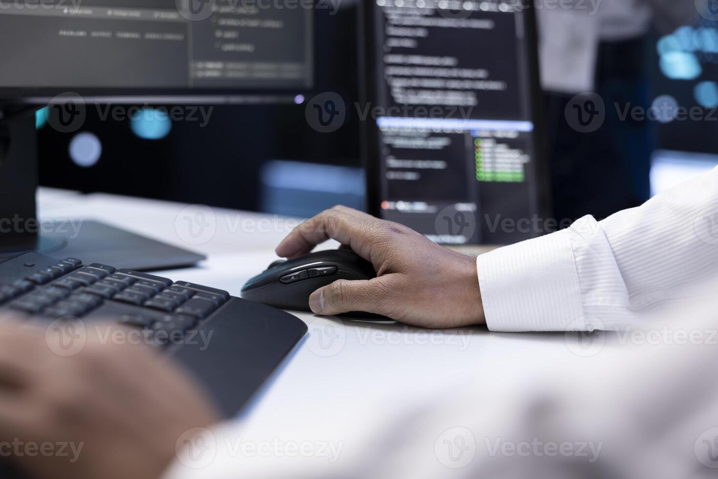 IT developer working on computer in server farm housing data management rigs, storage devices and networking devices providing vast amounts of computing resources, doing infrastructure maintenance photo