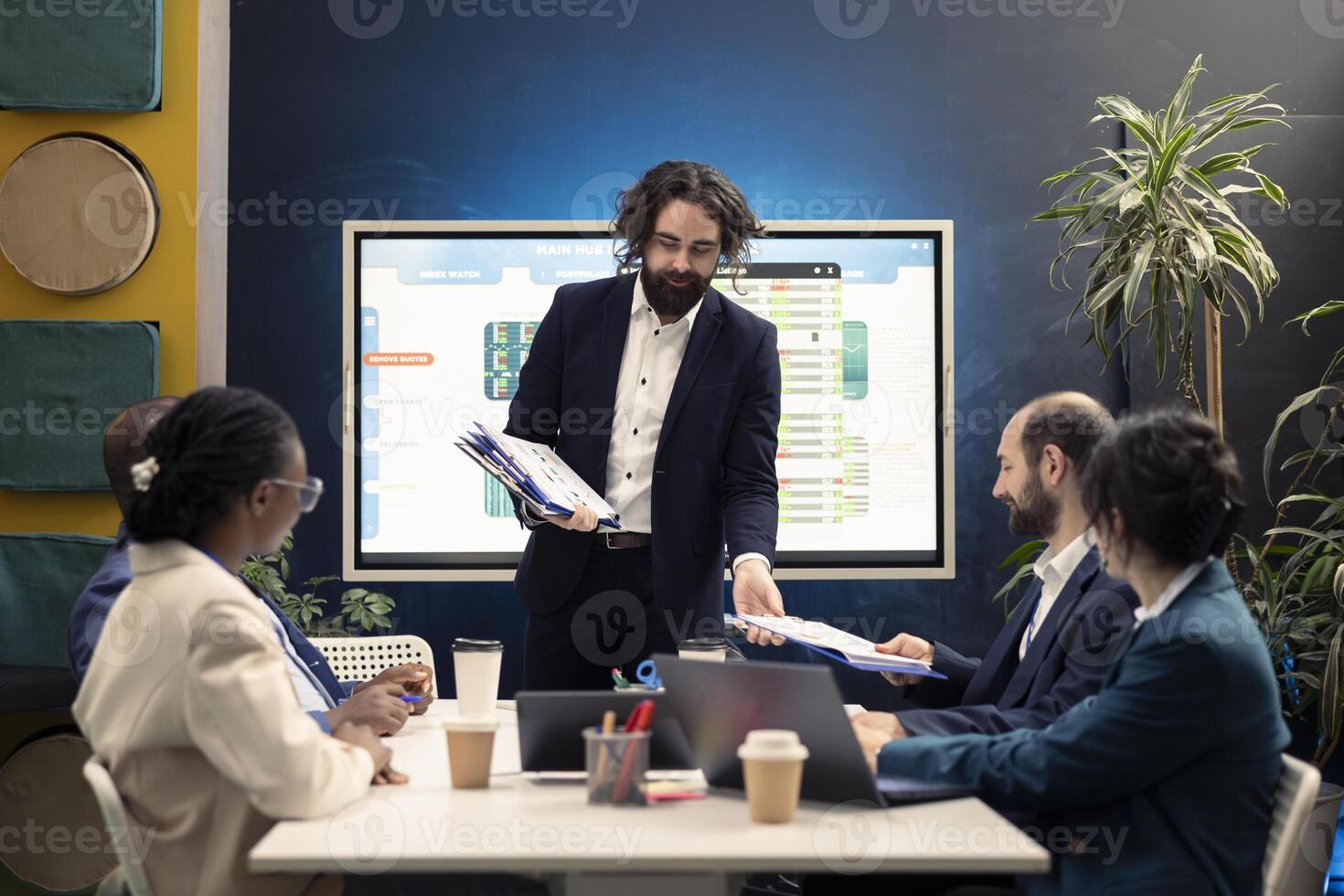 During an organizational reporting conference, group manager distributes papers with current statistics on performance. Team leader debates productivity at work and optimization. photo