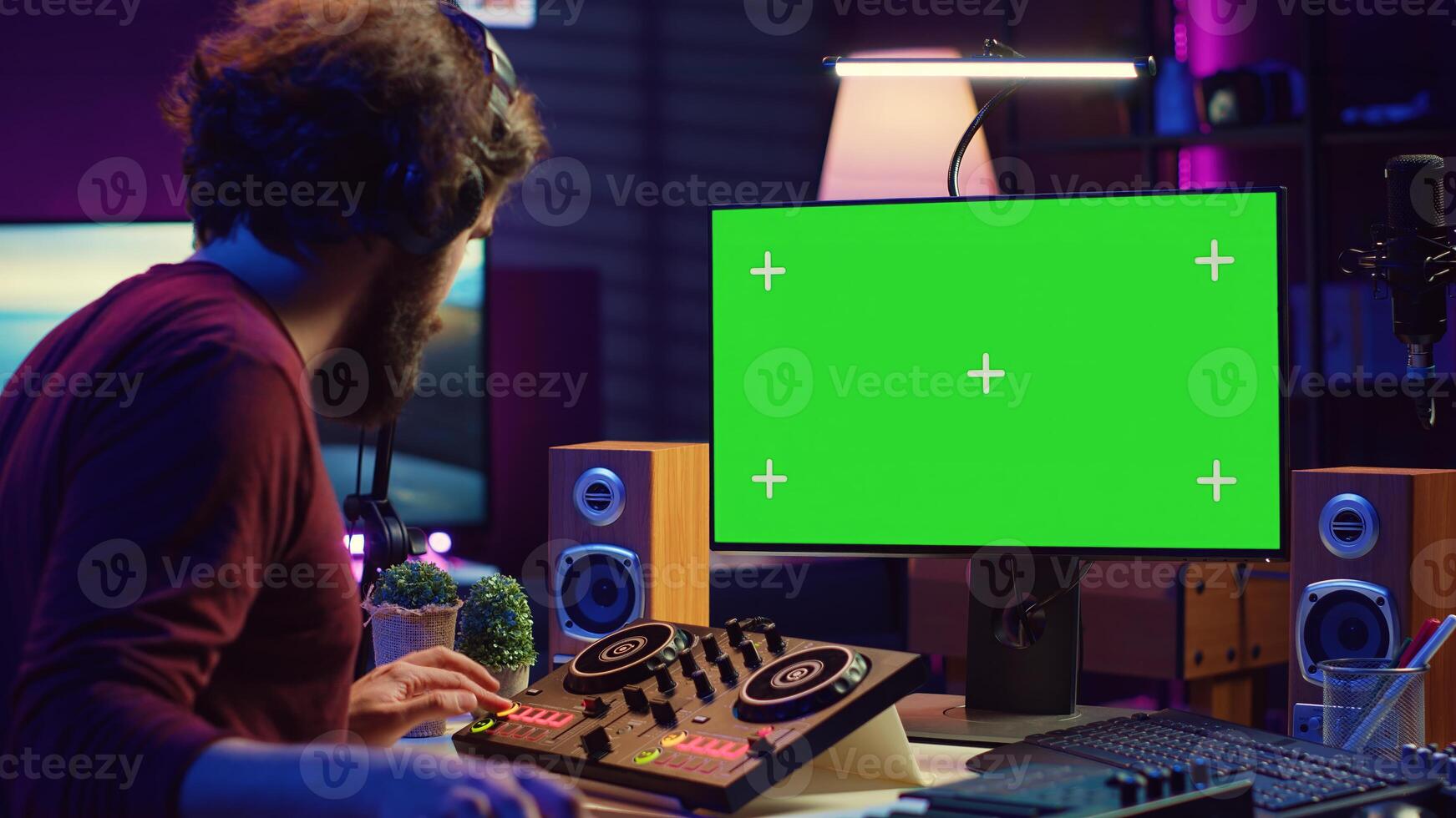 Audio engineer learning to mix piano notes with mixing console, watches online lesson tutorials on greenscreen monitor display. Music producer creating soundtracks, learns editing skills. Camera A. photo