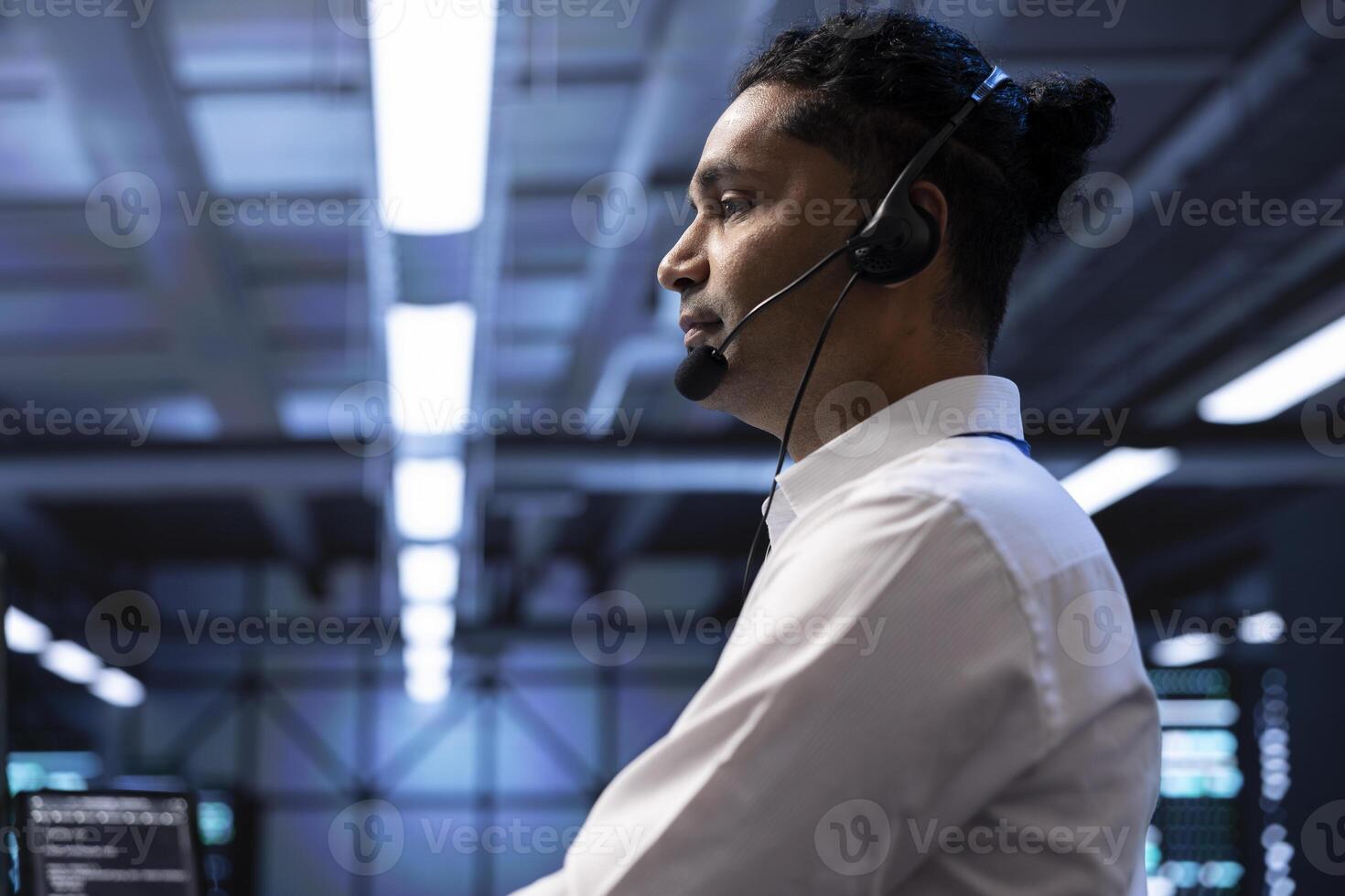 IT specialist in data center providing technical support to customers, troubleshooting issues, close up. Server farm worker carrying out operational technical interventions requested by clients photo