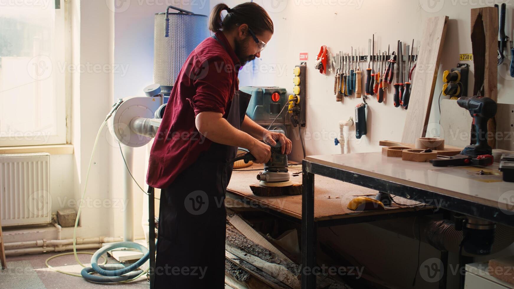Carpenter giving clipboard with blueprints to assistant, ready to use angle grinder on wood to smooth surfaces. Woodworker using orbital sander gear after consulting commission schematics, camera B photo