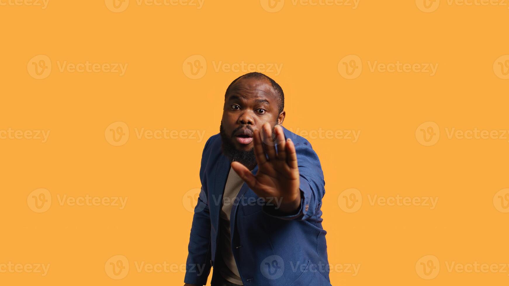 Stern african american man doing stop hand gesture sign. Annoyed BIPOC person doing firm halt sign gesturing, wishing to end concept, isolated over studio background, camera B photo
