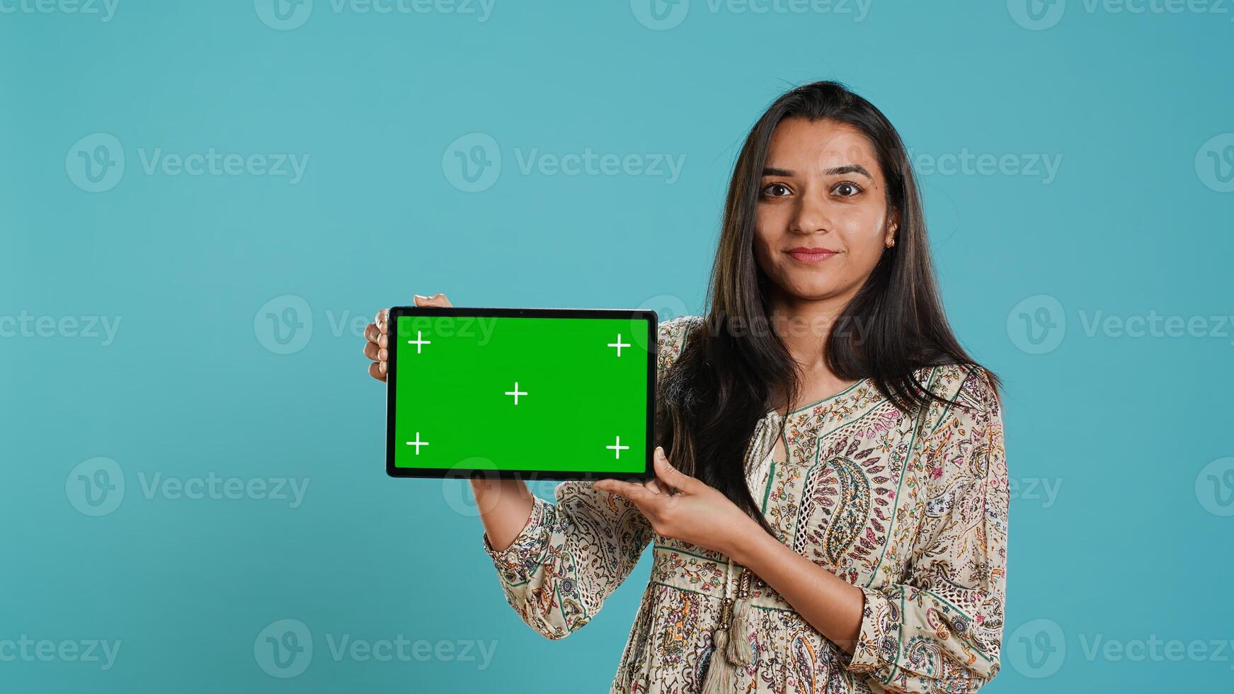 Energetic salesman doing influencer marketing using green screen tablet, studio background. Lively woman reviewing product, holding empty copy space mockup digital device, camera A photo