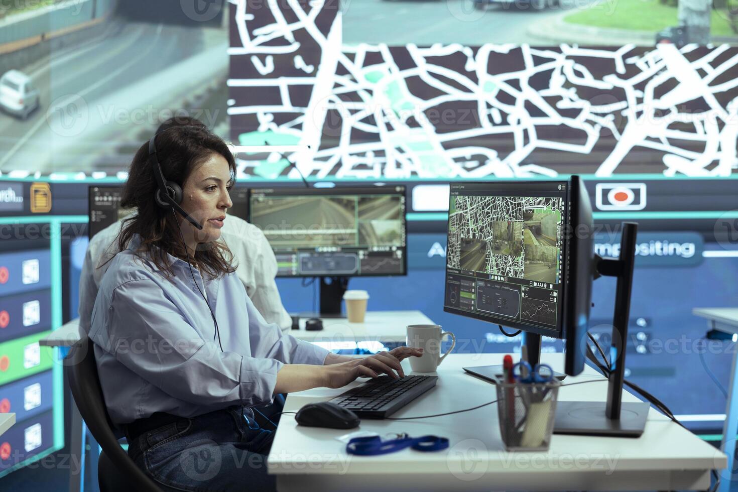 Call center employee gives updates on order location to clients, handling all dispatch complains in monitoring room at shipping agency. Operating on satellite navigation and radar. photo