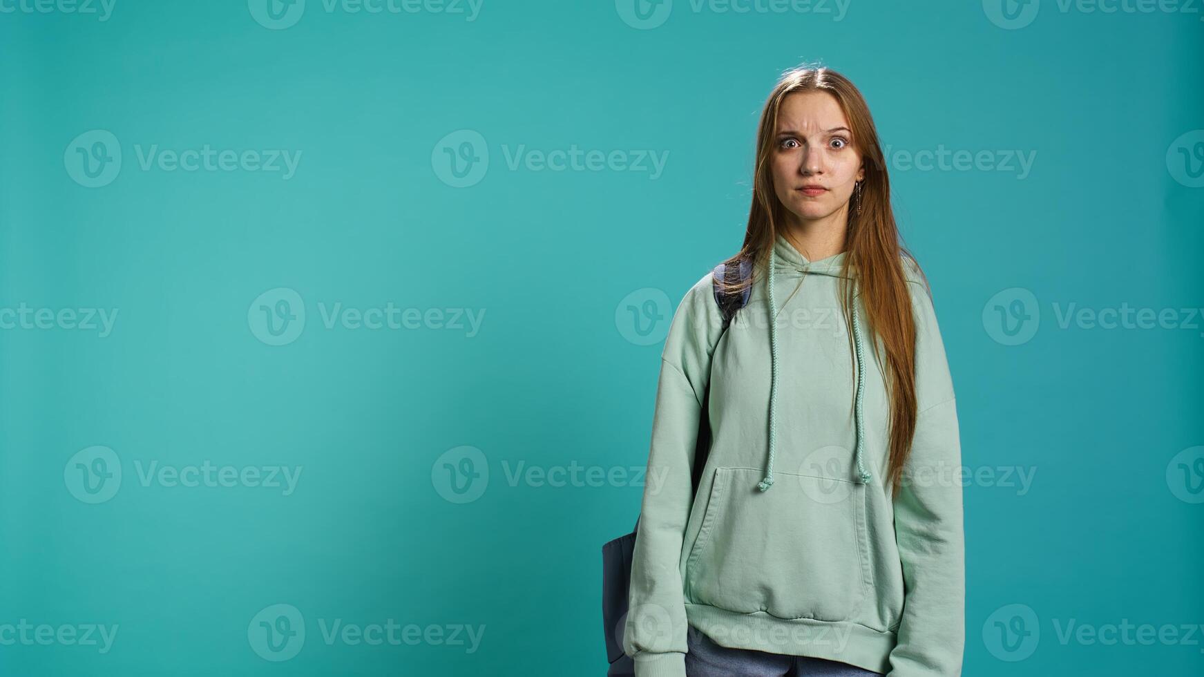 Young actress goofing around, switching emotions, trying different facial expressions, practicing for theatre class, studio background. Teenage woman making silly faces, camera B photo