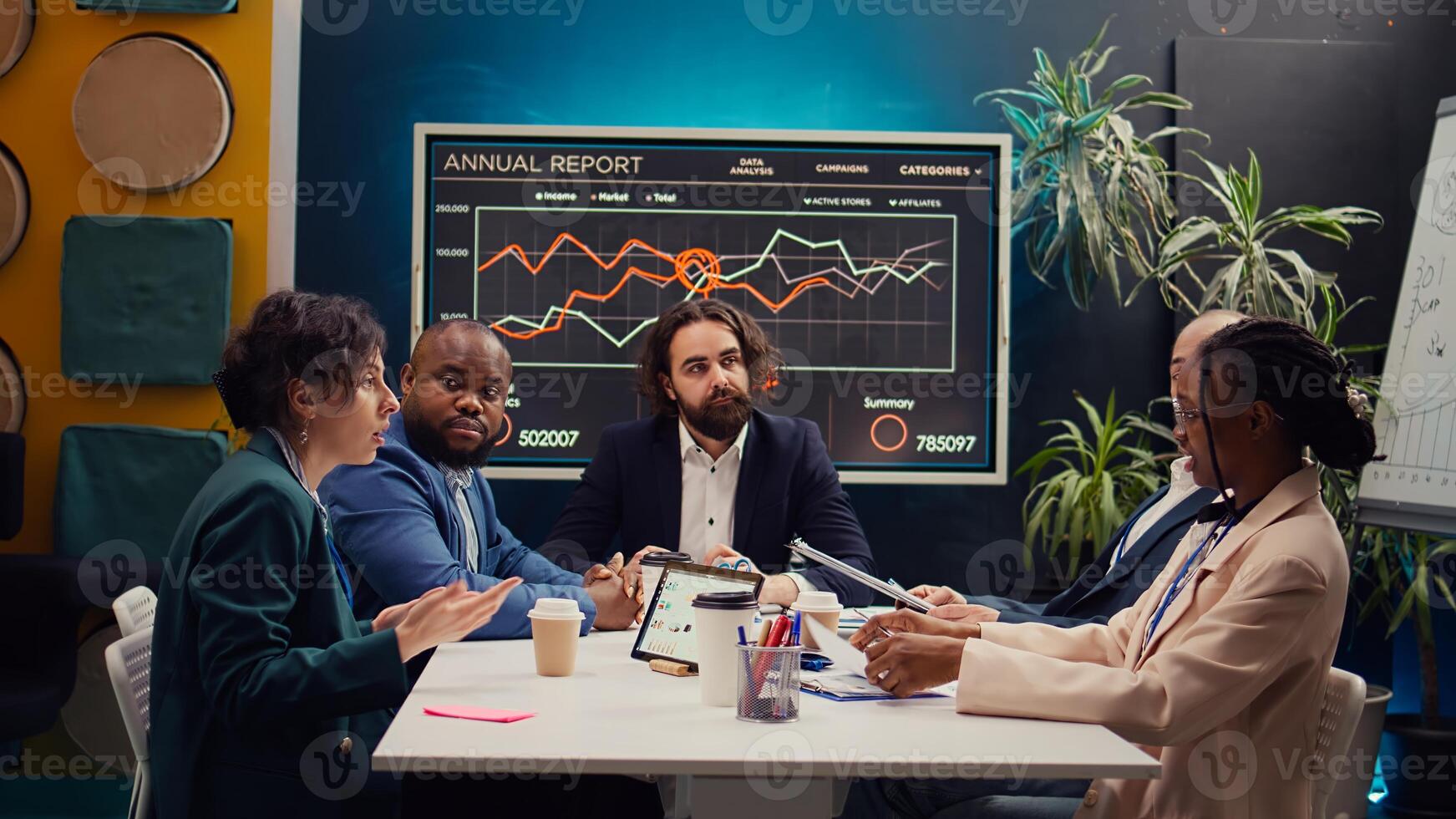 Business associates meeting to share insight and exchange impressions about infographics and statistics extracted from online research. Team collaborating on enterprise development plan. Camera B. photo