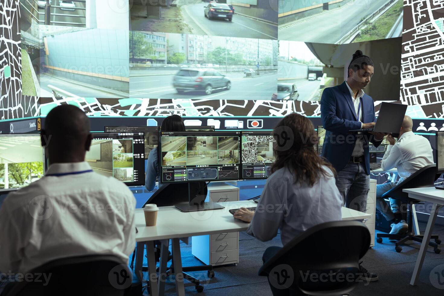 Indian supervisor and his staff following their delivery cars in traffic, finding best routes through surveillance CCTV cameras to provide coordinates to the couriers. Control center satellite map. photo