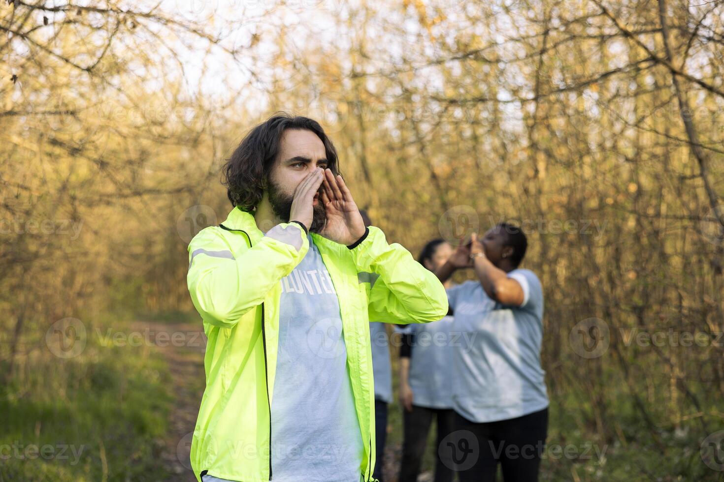 Rescue party captain leading people through the forest to track steps during searching mission to locate missing person. Yelling individual's name, civil disappeared in a woodland area. photo
