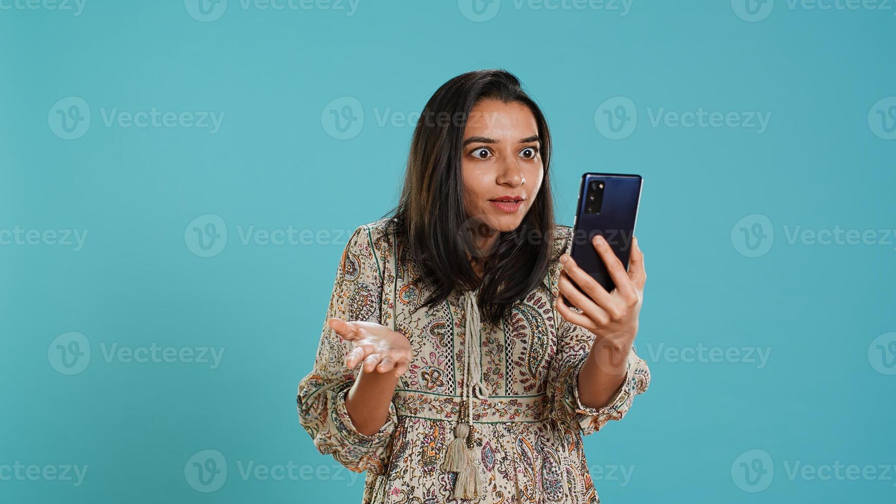 Irked woman fighting with friends during smartphone videocall, isolated over studio background. Outraged person arguing with mates during conversation on mobile phone, camera A photo