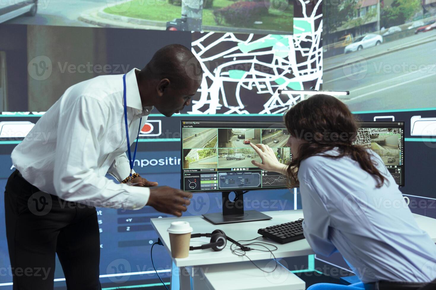 African american supervisor gives instructions to his staff in finding gps coordinates on satellite map, guiding couriers through CCTV surveillance footage. Order tracking and locating. photo