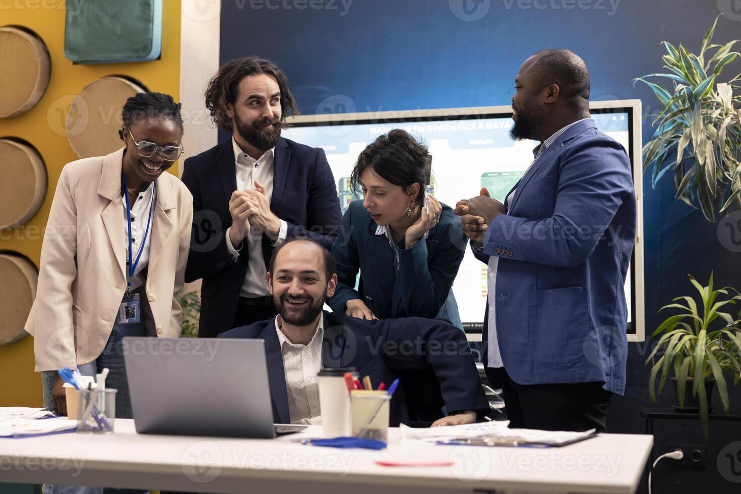 Finances team look at stock market trends and celebrating their victory in acquiring more capital for development. Satisfied cheerful workers and manager feeling proud about their team progress. photo