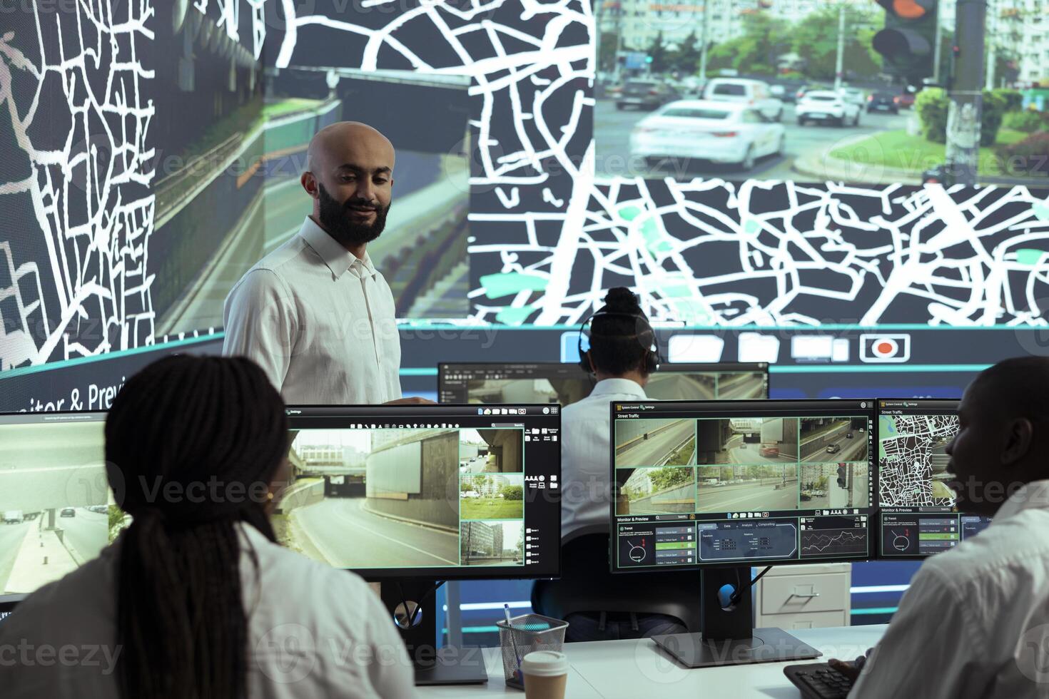 Middle eastern team leader instructs his staff to monitor delivery trucks activity around town, working to ensure express shipping service. Manager oversees cargo and parcel transportation. photo