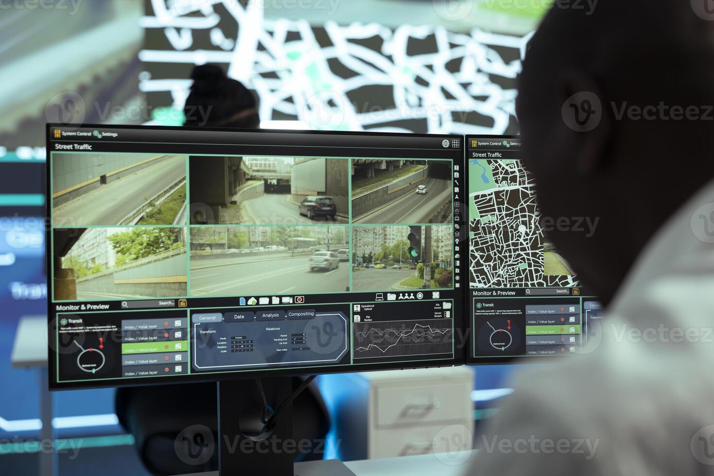 African american operator monitoring traffic on streets and locating couriers, tracking parcels to update clients on order shipment. Male employee operates on CCTV footage, gps tracing. photo