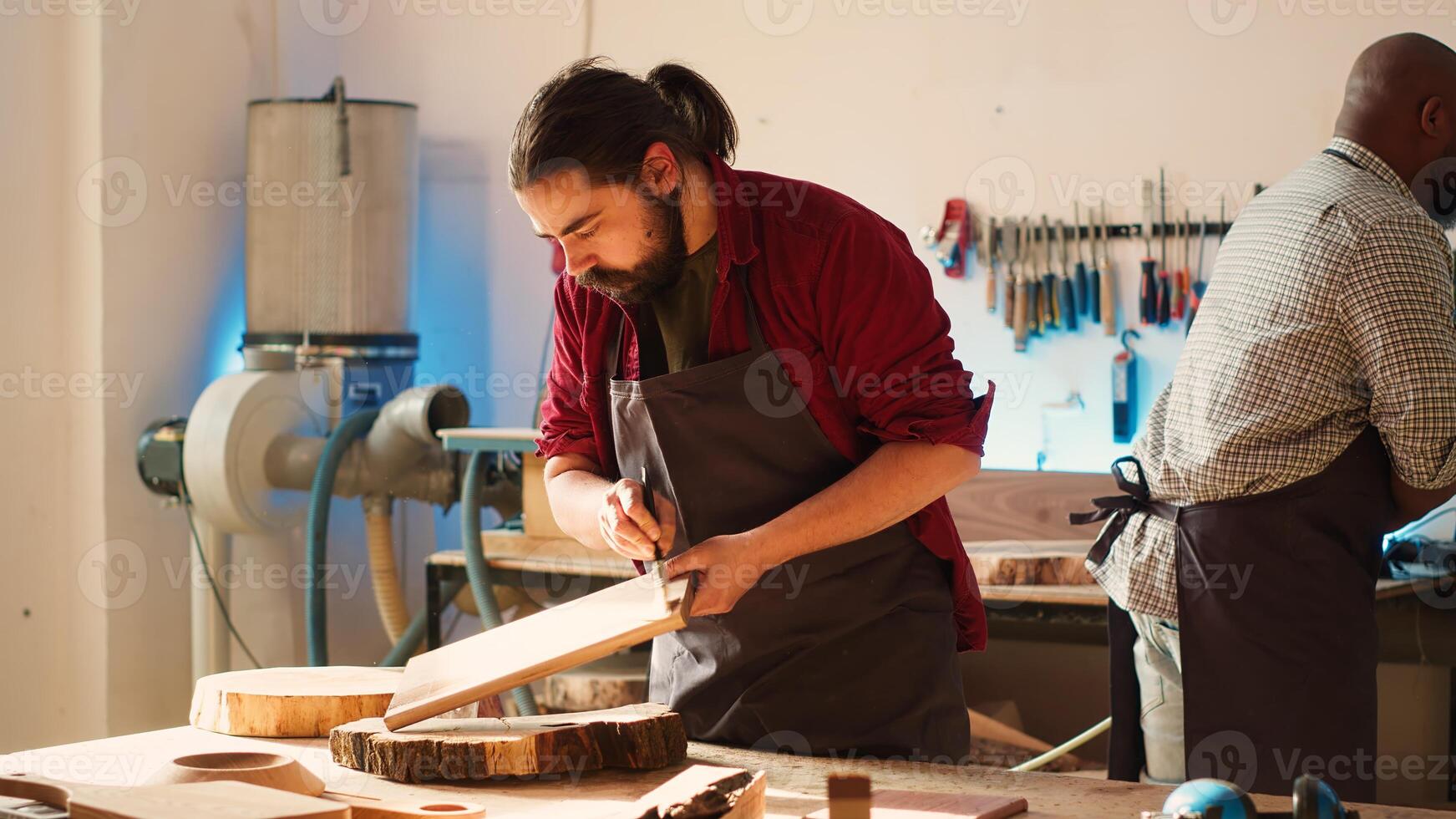 Carpenter in assembly shop starting renovation project on timber block, applying lacquer on surface. Woodworking specialist coloring wood plank with paintbrush, enjoying diy hobby, camera A photo