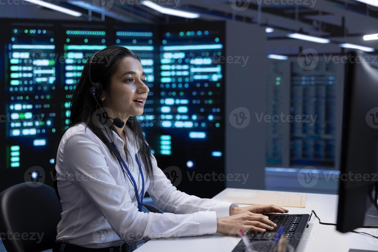 Smiling engineer in data center providing support for companies, troubleshooting malfunctions. Happy worker in server hub carrying out operational interventions requested by enterprise clients photo