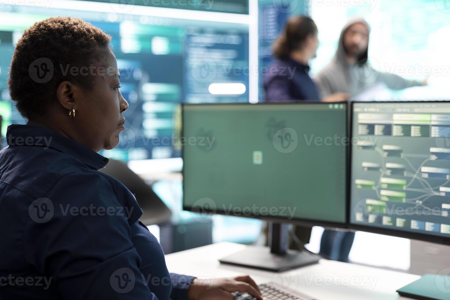 Woman governmental hacker analyzing digital threats on a computer, working in professional agency with a big screen. Specialist collecting information, fighting against cyberterrorism. photo